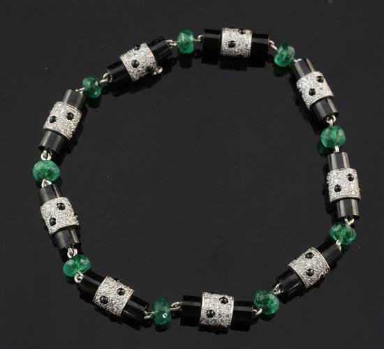 A white gold, emerald, diamond and black onyx set bracelet, 7.5in.